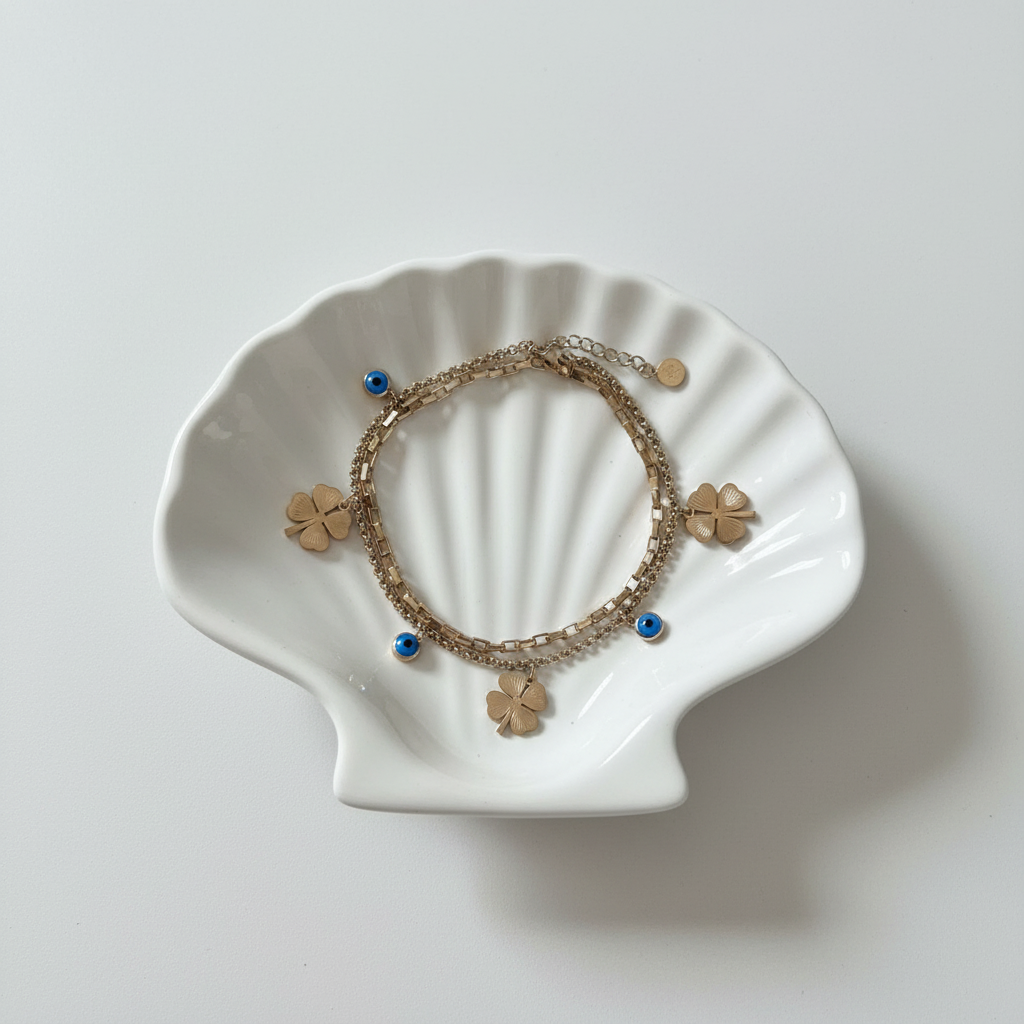 Clover evil eye charm bracelet flat lay gold lucky protection bracelet for women