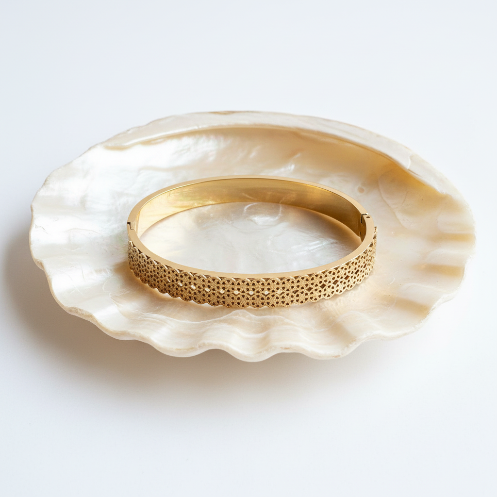 Textured gold bangle bracelet flat lay with shell tray