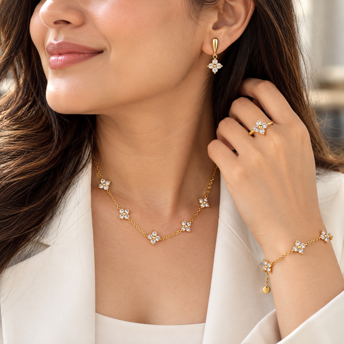 Woman wearing Flora Four-Petal Crystal necklace, earrings, ring and bracelet