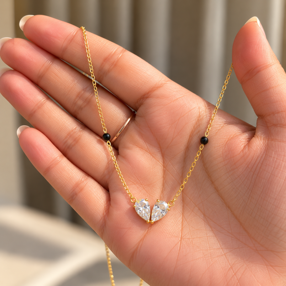 Delicate Elara Modern Mangalsutra with black beads and twin pear crystals in hand