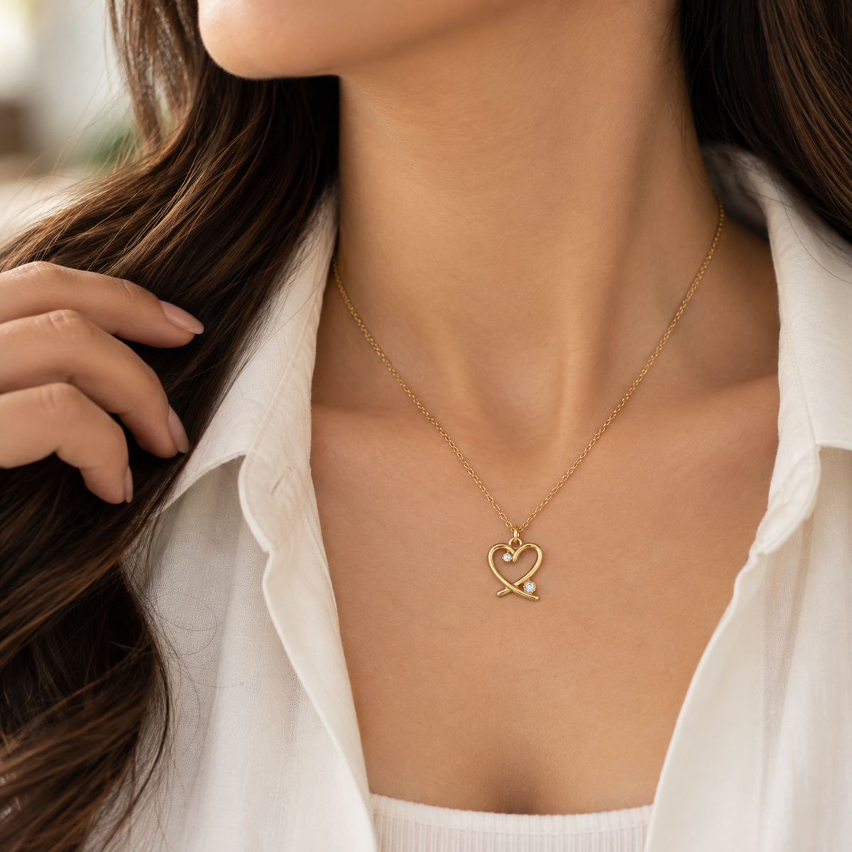 Woman wearing Amorette delicate gold-tone crystal heart necklace with a minimal outfit