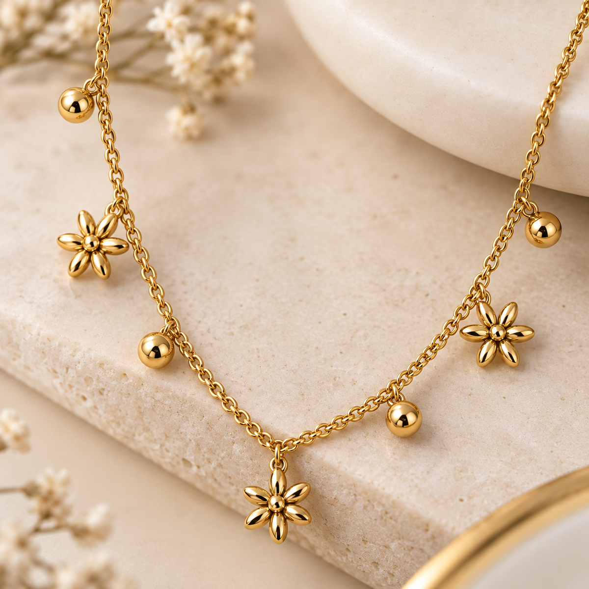 Close-up of Aveline necklace showing gold-tone flower charms, bead accents and chain detailing