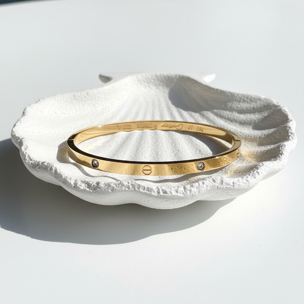 Love bangle bracelet gold plated minimal bracelet flat lay on white shell tray