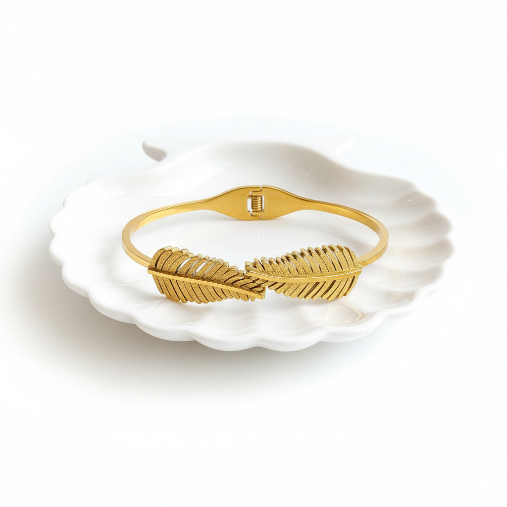 Gold plated leaf feather bangle stainless steel bracelet flat lay minimal gold feather bracelet for women