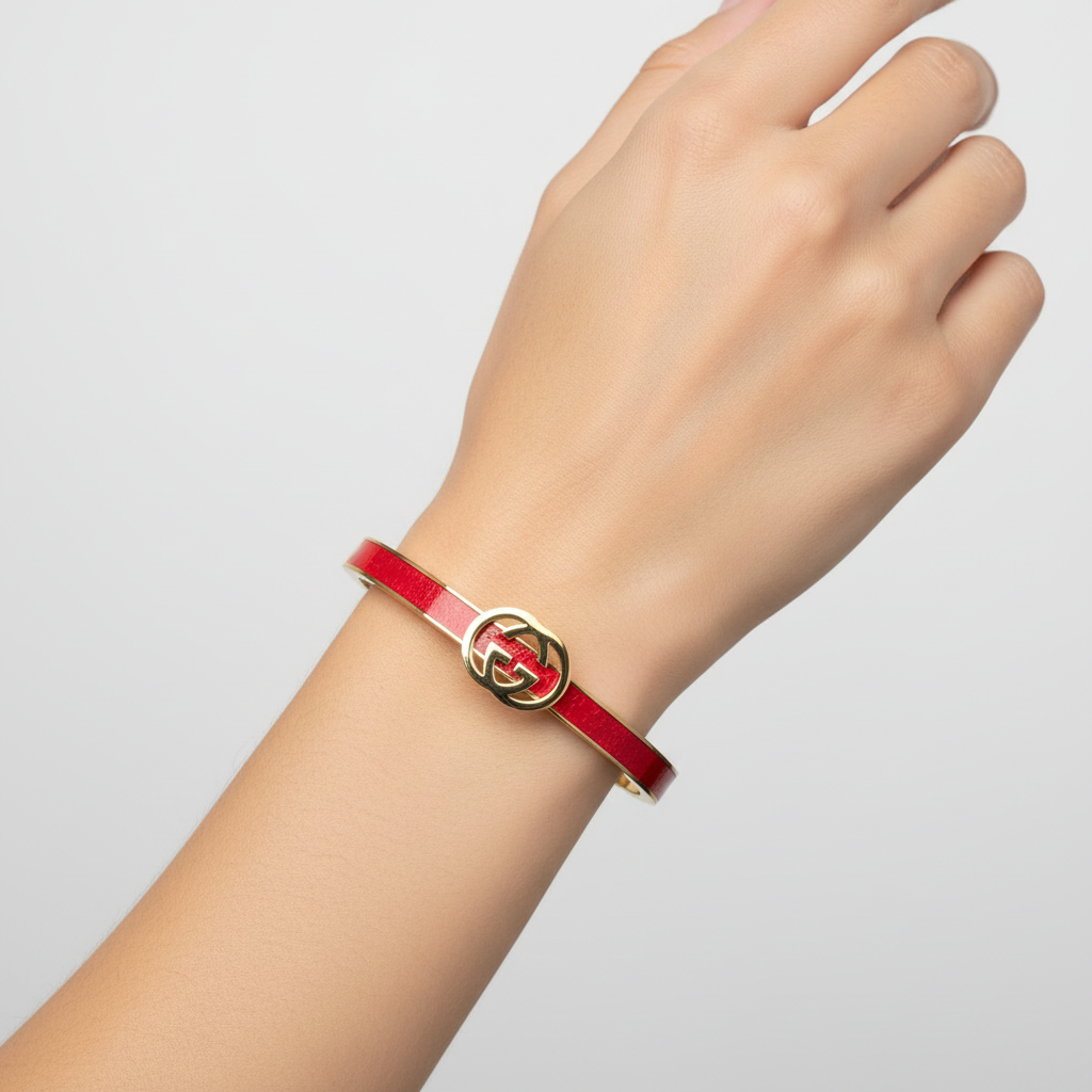 Woman wearing red designer logo bangle bracelet minimal gold bracelet for everyday wear