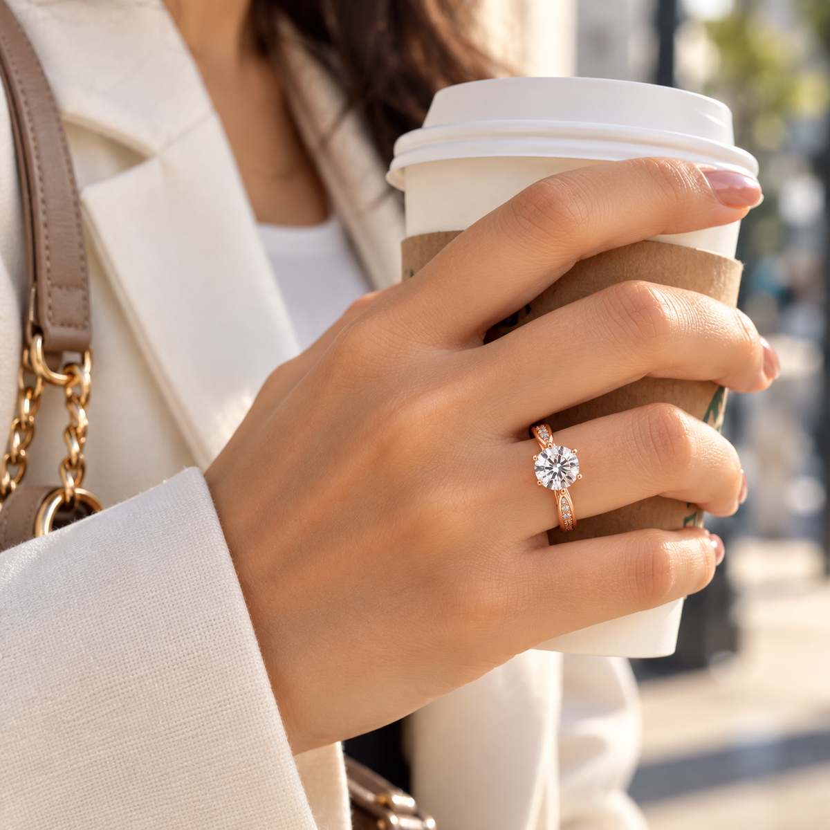 Woman wearing Roselle rose gold crystal solitaire ring while holding a coffee cup
